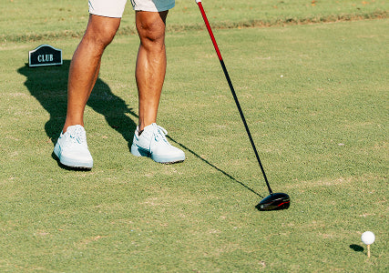 Person on a golf course preparing to putt with a putter wearing Beta Longwing Shoe Sky/Navy