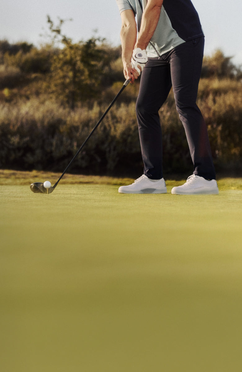 Two golfers on a golf course with a scenic background wearing Beta Lite and Beta Longwing