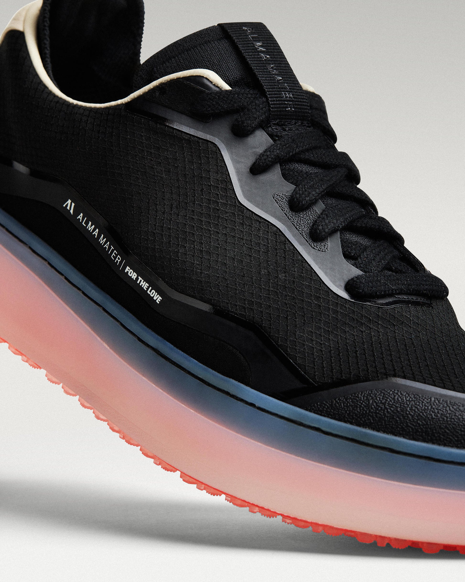 Close-up of black and flare Beta Lite golf shoe showing textured mesh upper and stitching detail