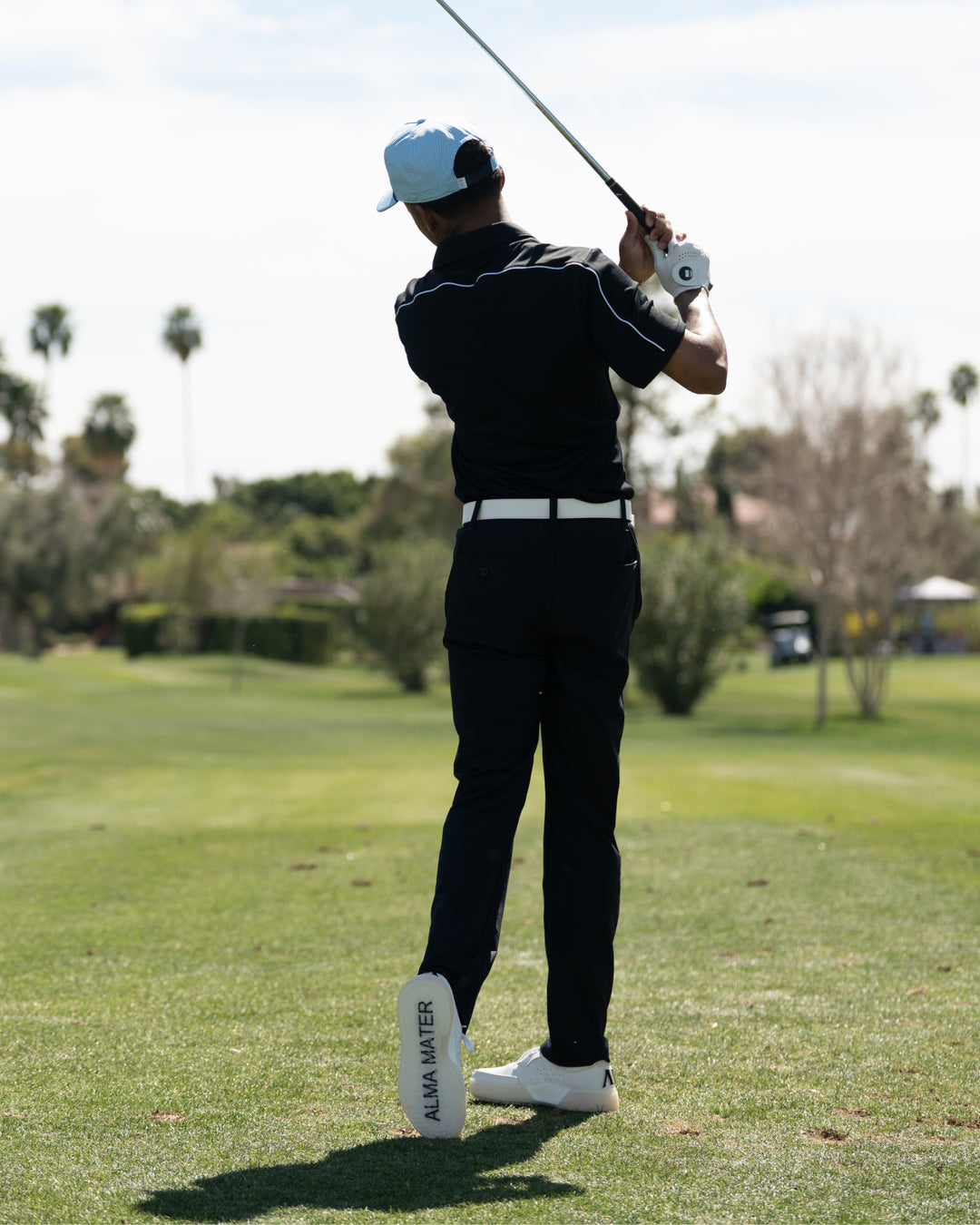 Golfer in black outfit swinging a golf club on a golf course wearing Beta Lite White/Grey golf shoes