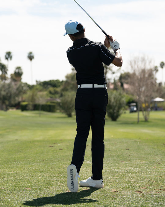 Golfer in black outfit swinging a golf club on a golf course wearing Beta Lite White/Grey golf shoes