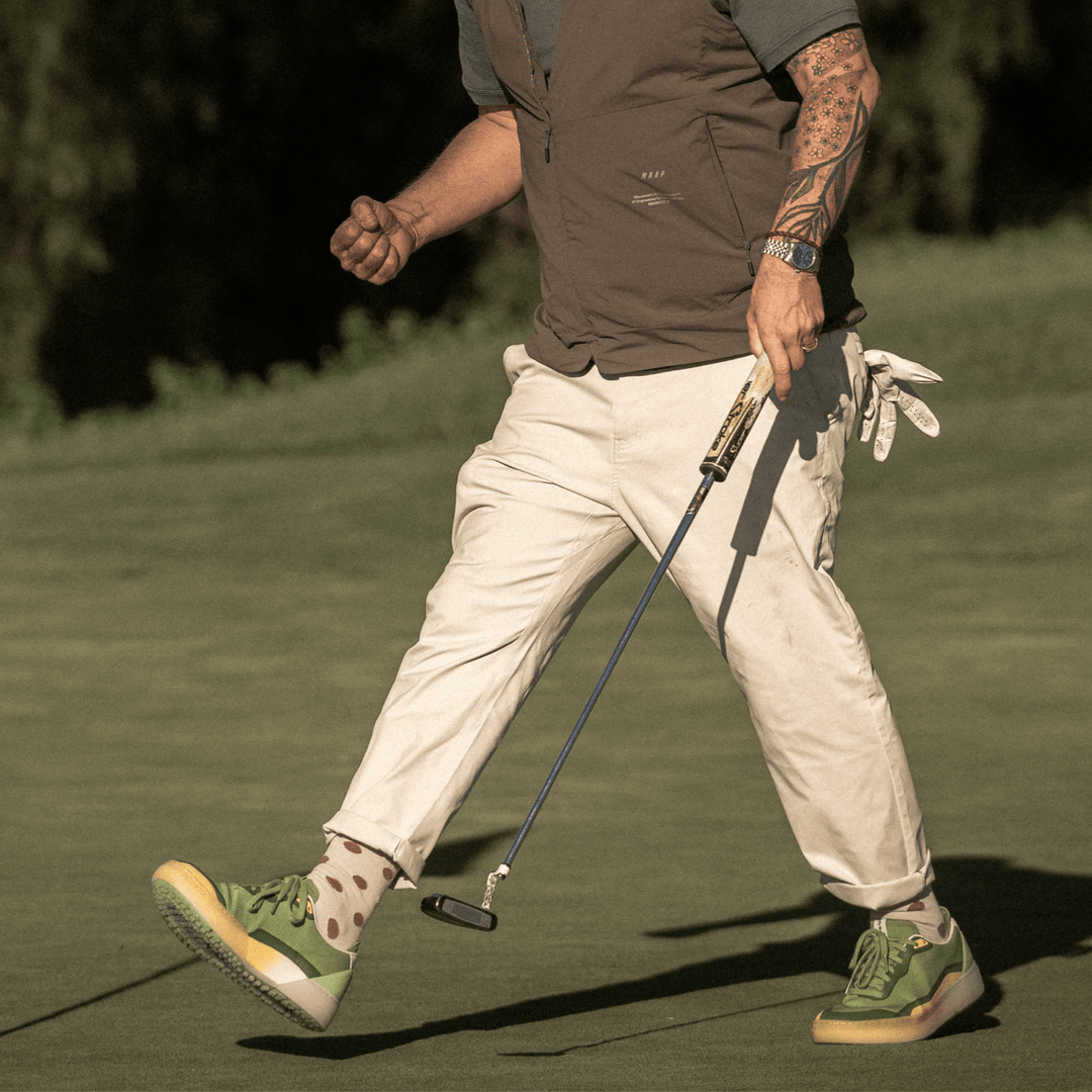 Lifestyle image of a golfer mid-stride on the fairway wearing the Olive and Aqua Beta Lite, showcasing flexibility, traction, and lightweight performance.