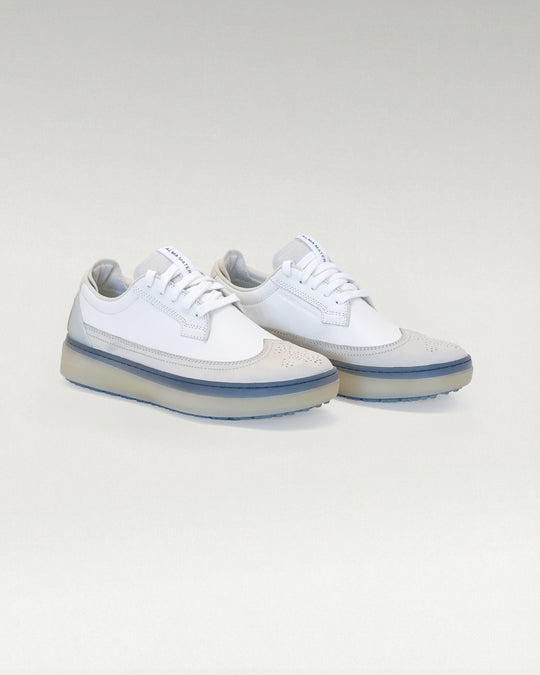 Angled view of white and navy Member Longwing PGA sneakers