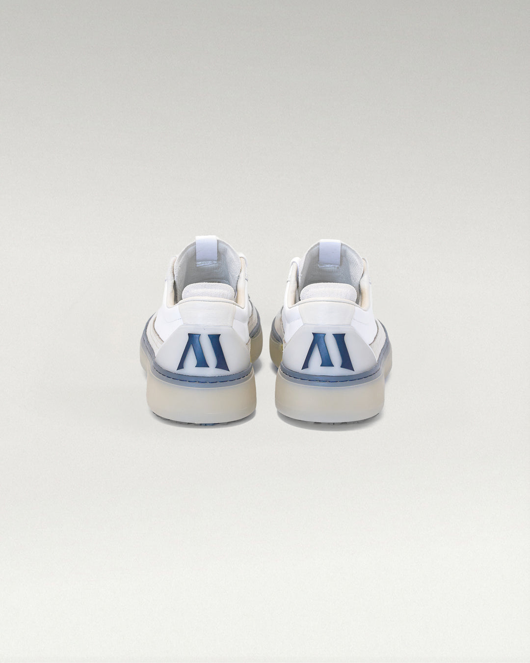 Back view of white and navy Member Longwing PGA sneakers with heel logo detail