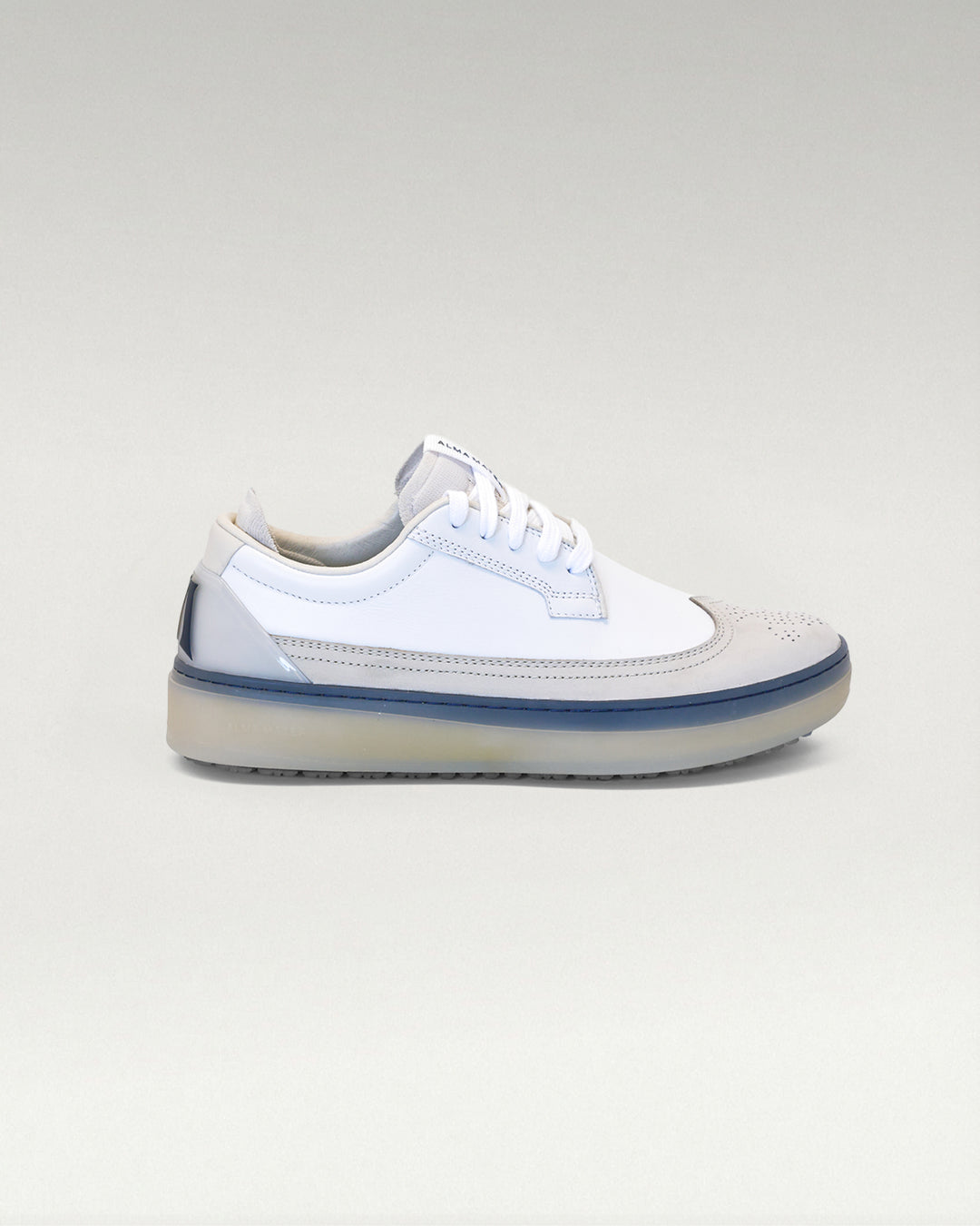 Lateral side view of white and navy Member Longwing PGA sneaker