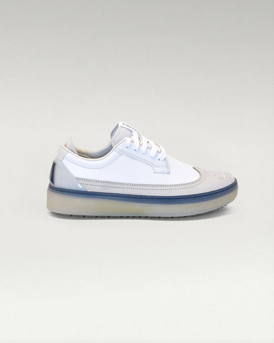 Lateral side view of white and navy Member Longwing PGA sneaker
