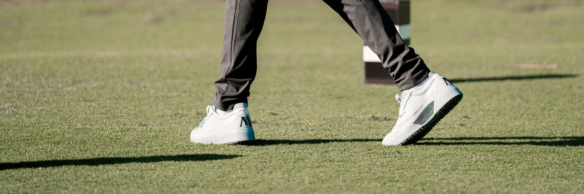 Man wearing Beta Longwing in Sky/Navy on a putting green. 