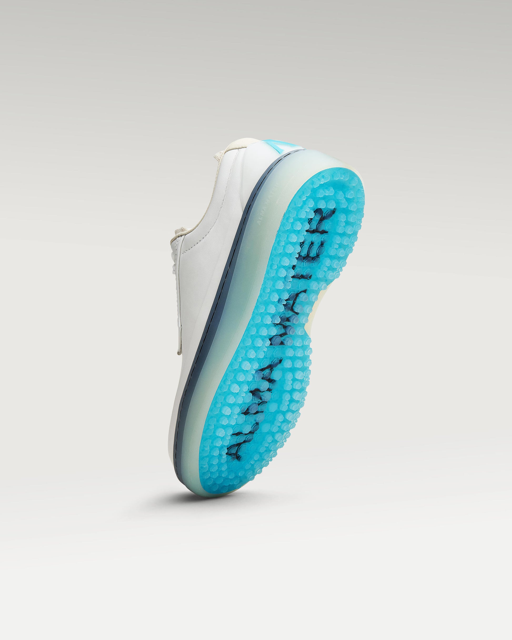 Bottom view of white and aqua Beta Derby golf shoe showing traction pattern