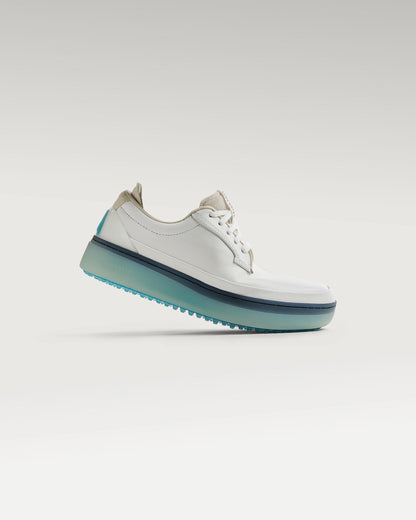 Side view of white and aqua Beta Derby golf shoe, showcasing flex