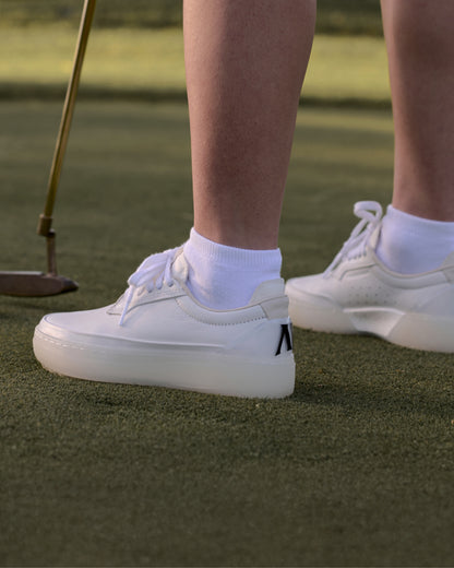 White Beta Derby on a golf course with a focus on the shoes.