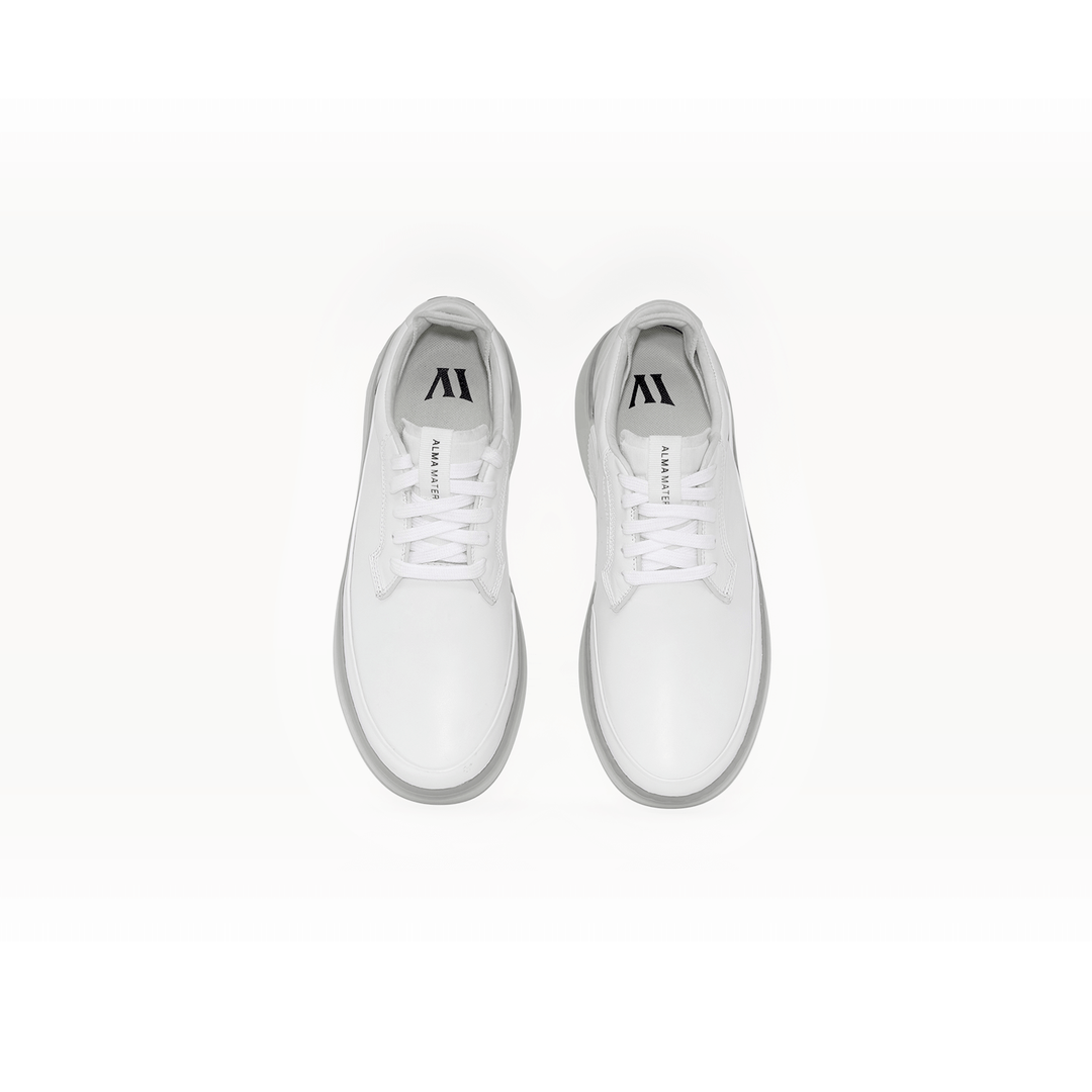 Top-down studio view of the Women’s Beta Derby in all white, shown as a pair with lace-up closure, smooth leather upper, and Alma Mater branding on the tongue and insole.