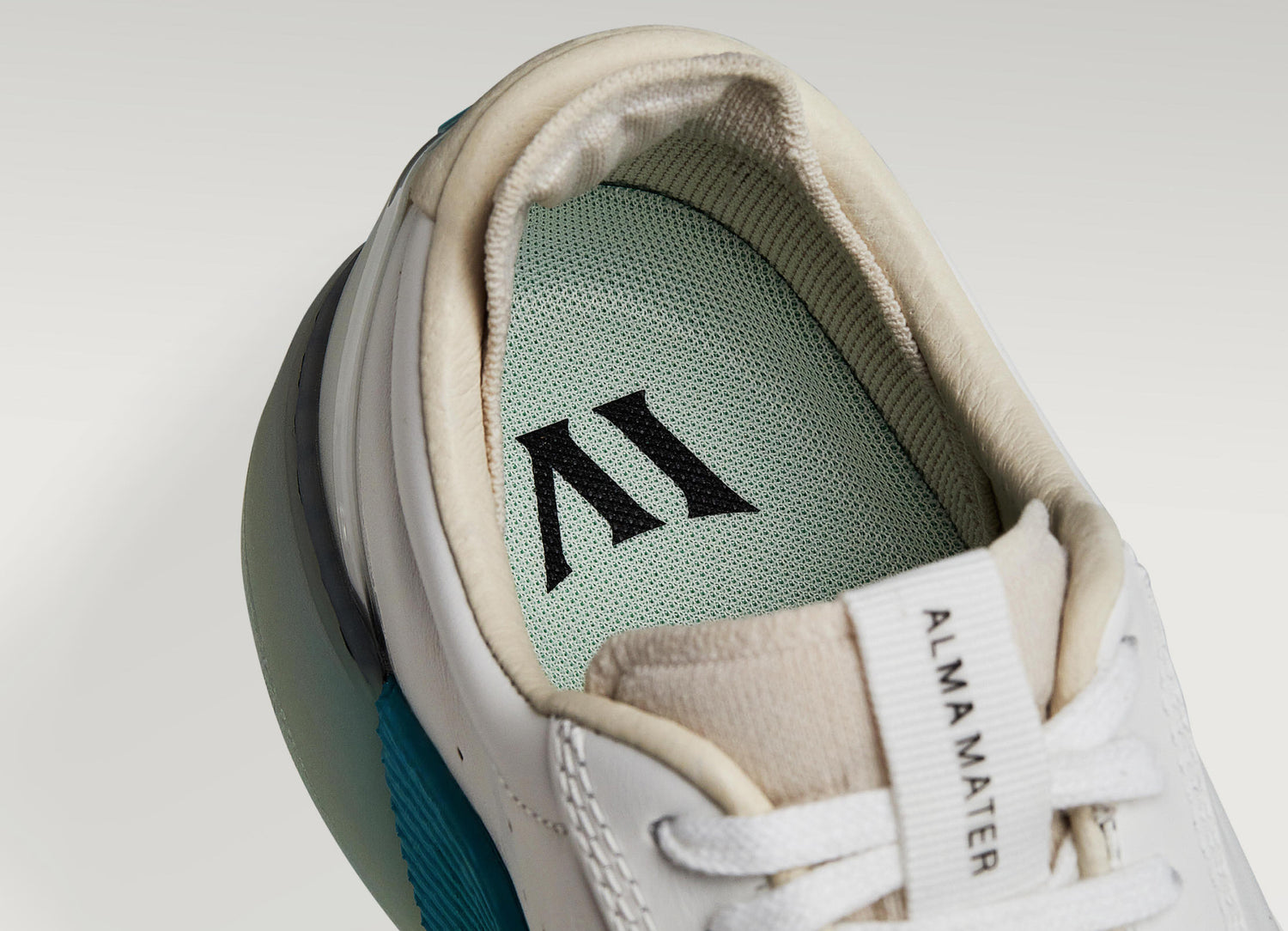 White and aqua Beta Derby sneaker with visible Alma Mater logo and cushioned interior, highlighting floating fit system