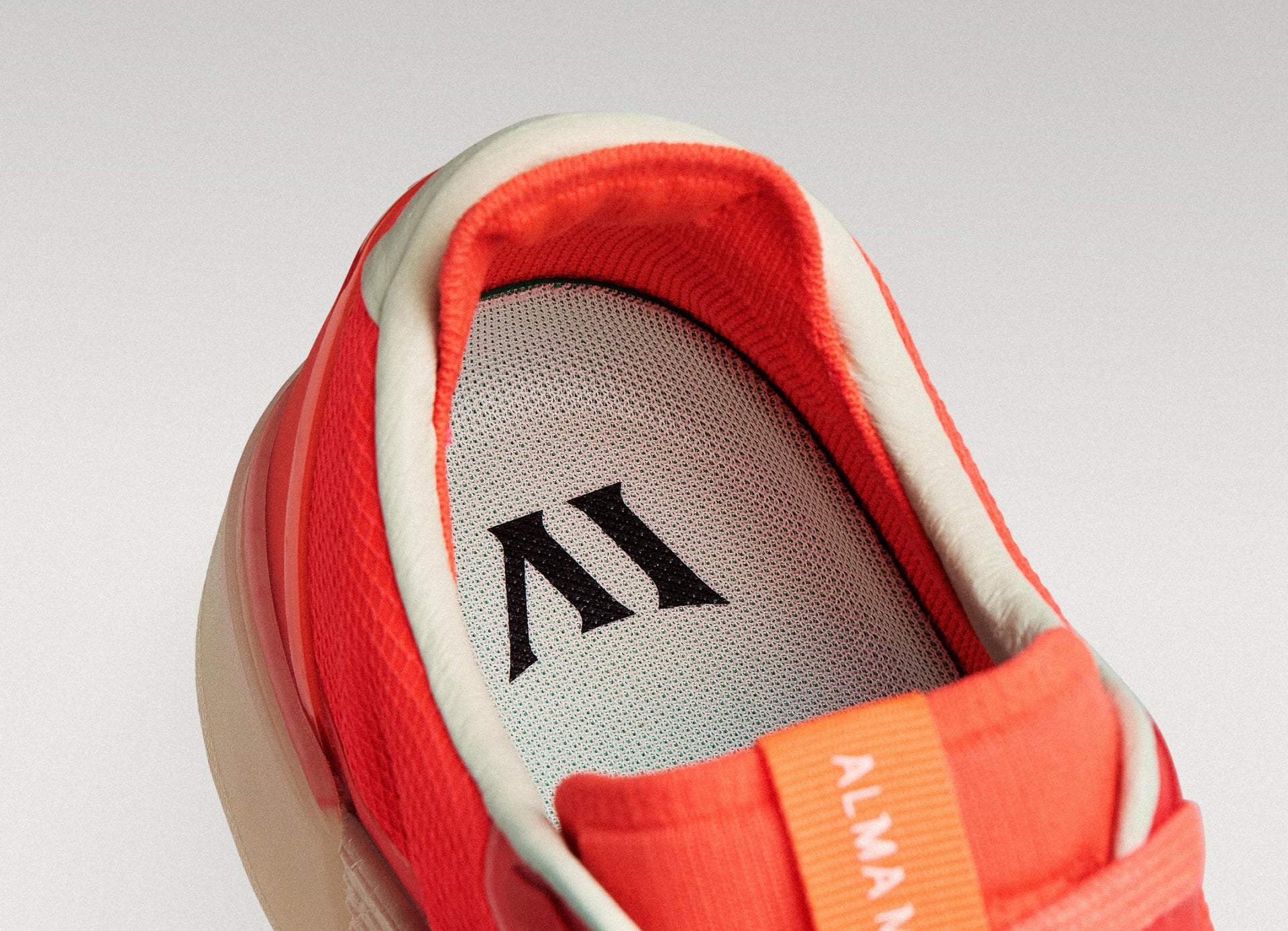 Close-up of a Beta Lite Flare/Old Rose with a green insole featuring a logo on a light gray background.