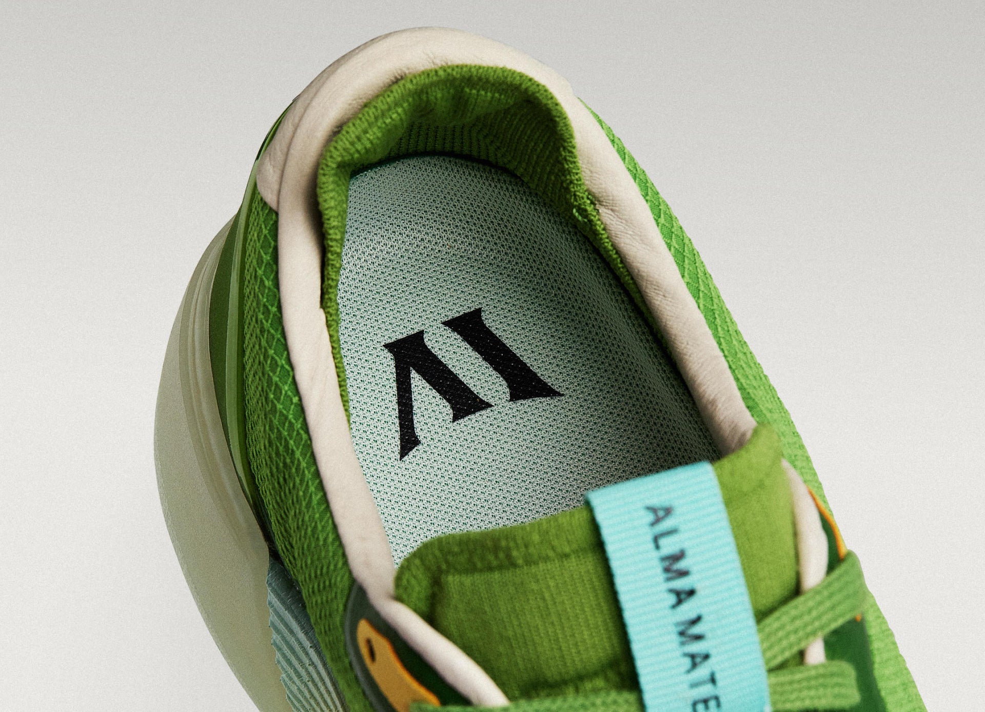 Close-up of a Beta Lite olive/aqua with a green insole featuring a logo on a light gray background.