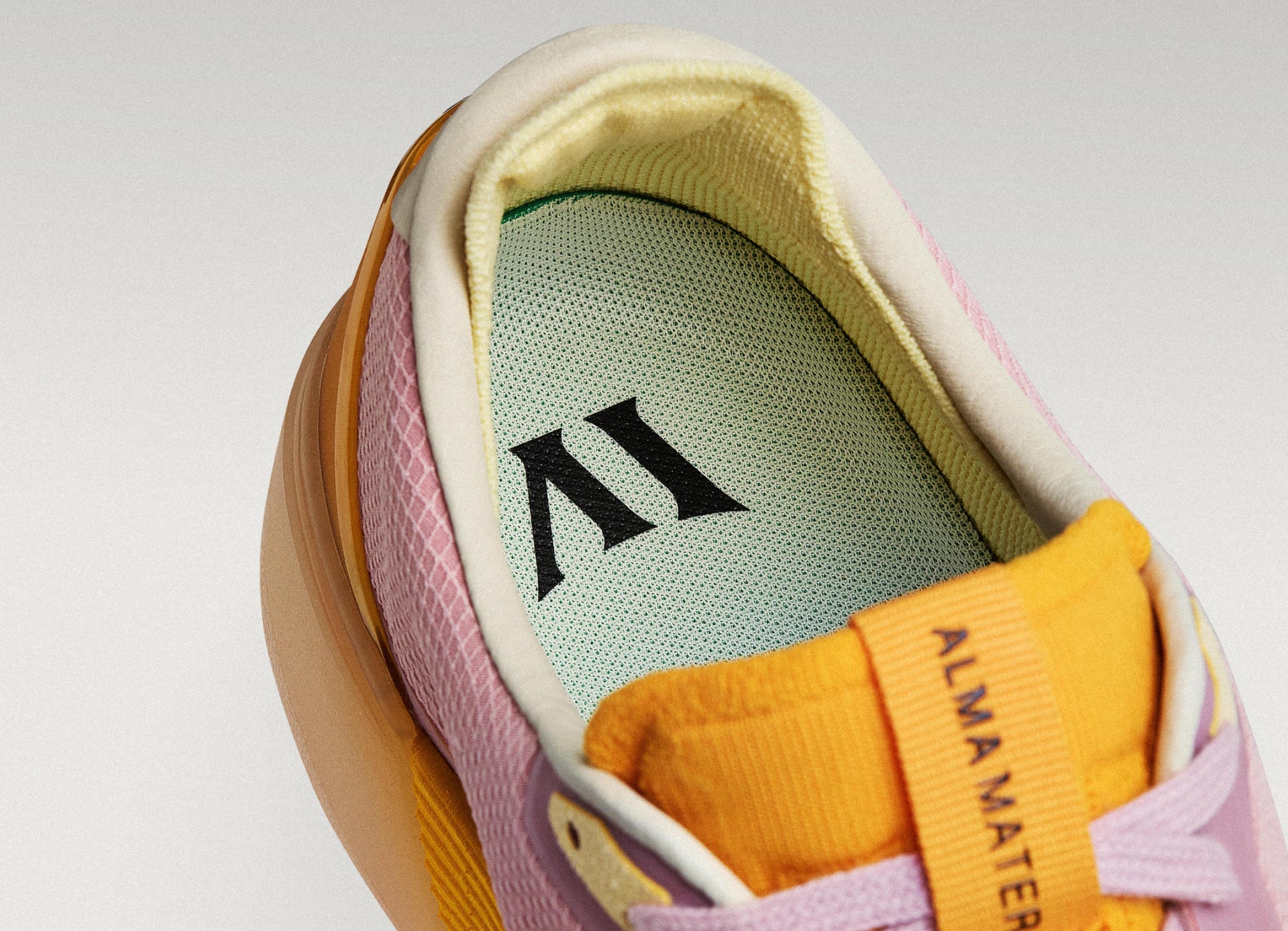 Close-up of a Beta Lite lavender-orange with a green insole featuring a logo on a light gray background.