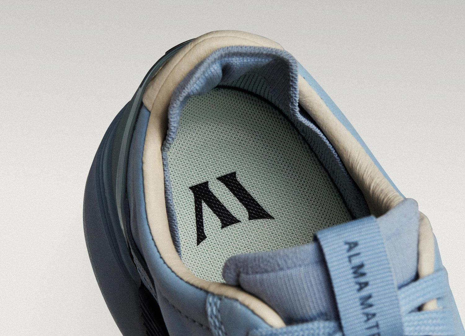 Sky/Navy Beta Longwing sneaker with visible Alma Mater logo and cushioned interior, highlighting floating fit system