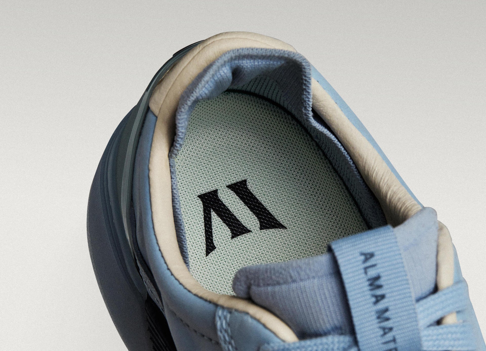 Sky/Navy Beta Longwing sneaker with visible Alma Mater logo and cushioned interior, highlighting floating fit system