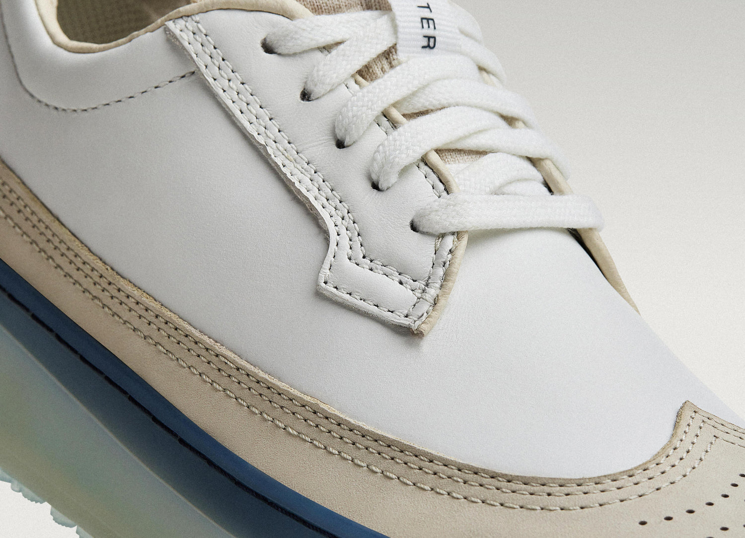 White/Navy Beta Longwing sneaker featuring smooth leather upper, stitching detail, and lace-up closure