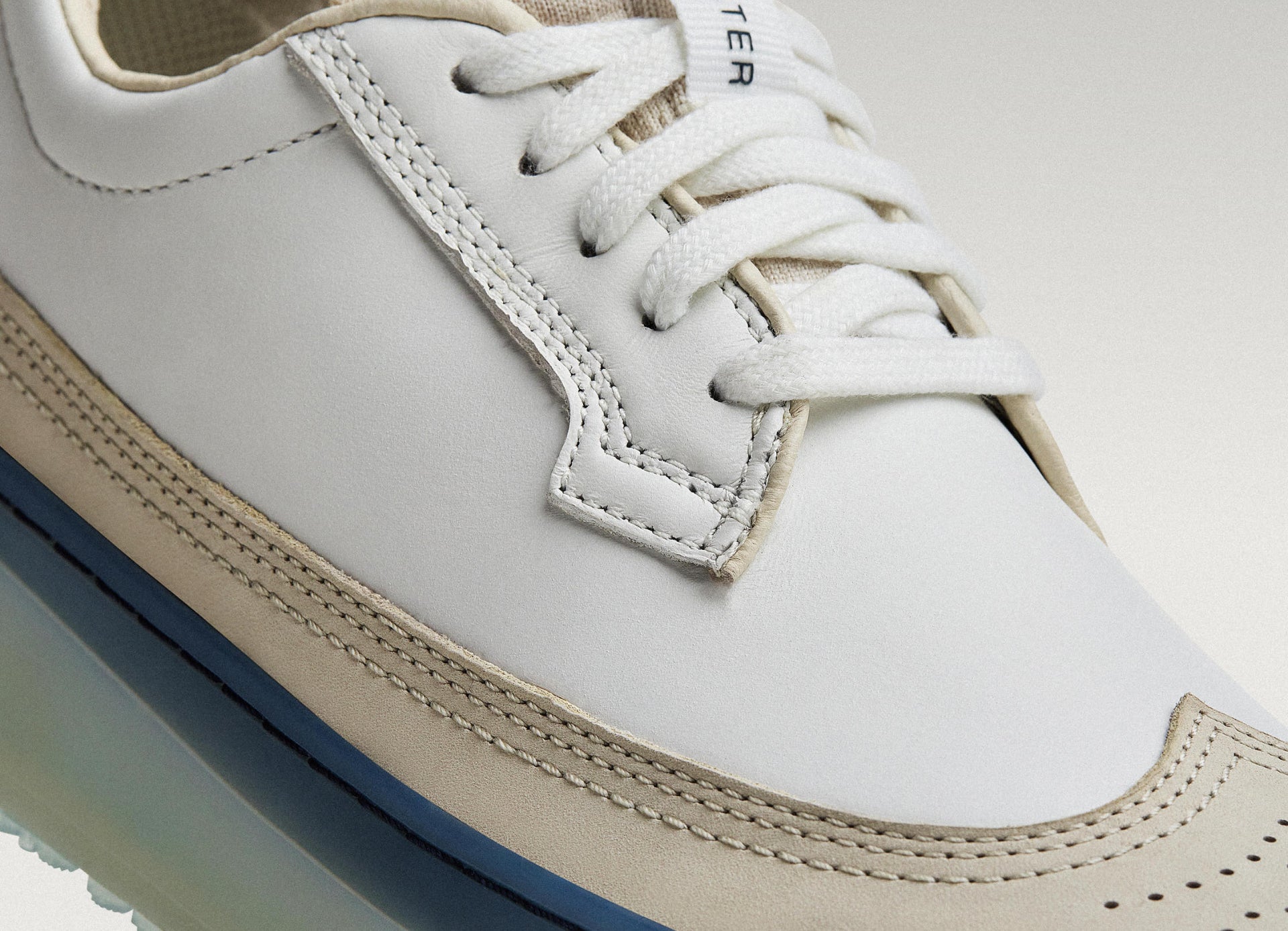 White/Navy Beta Longwing sneaker featuring smooth leather upper, stitching detail, and lace-up closure