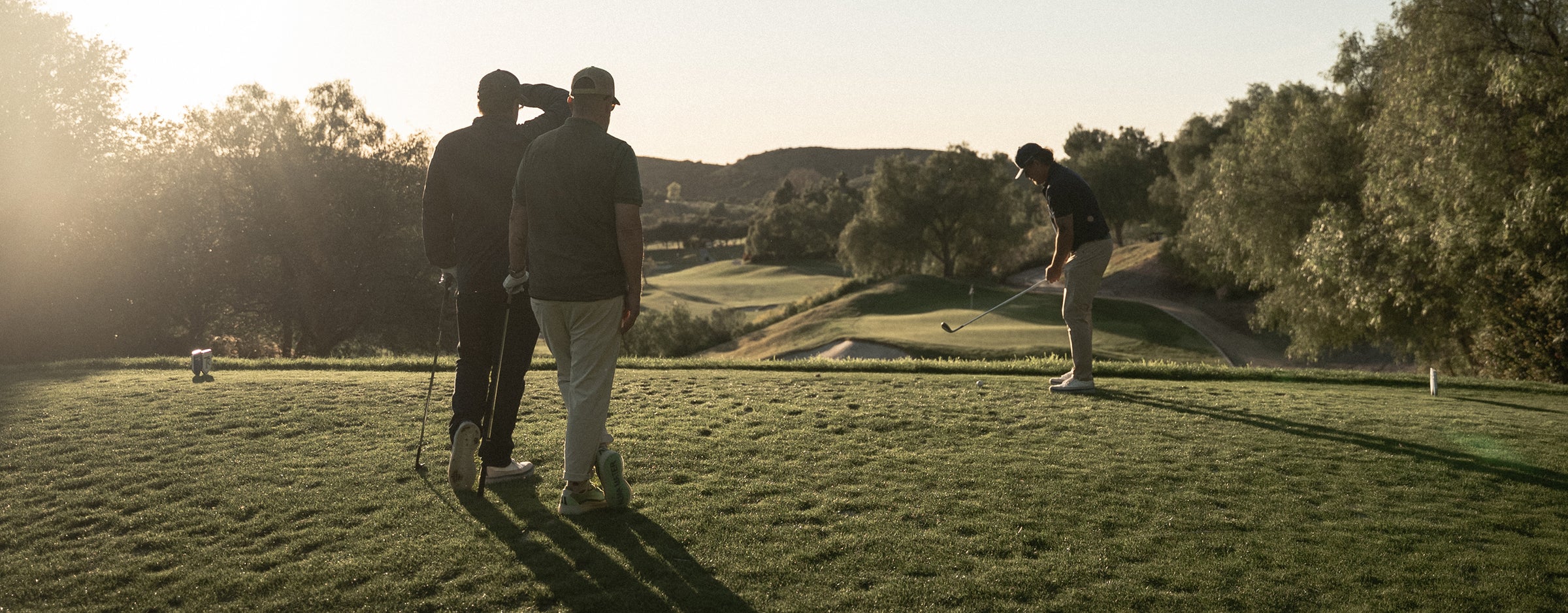 Golfers on a course with a scenic background
